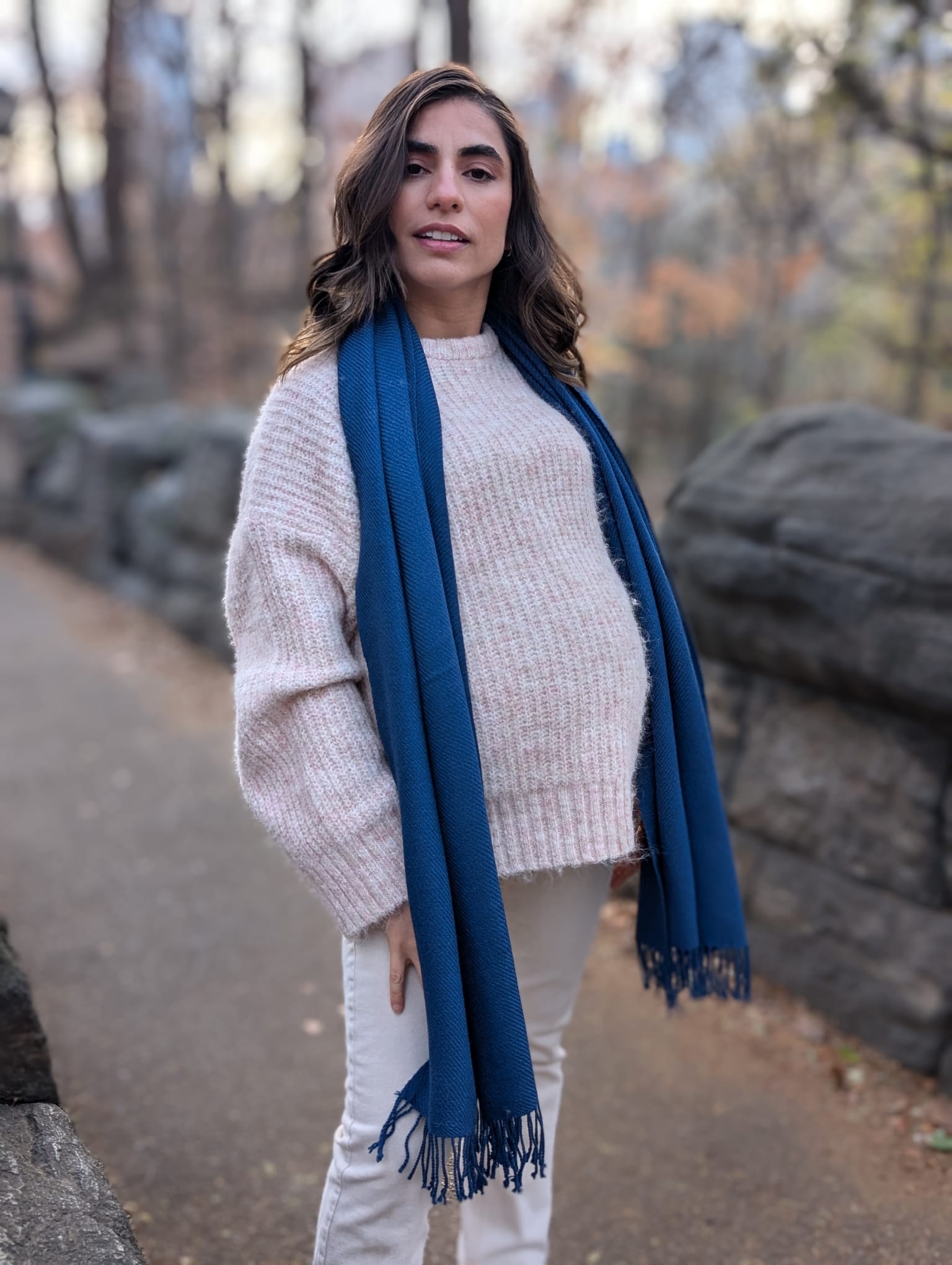 Woman wearing a blue scarf standing outdoors with a natural background
