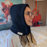 Woman wearing a black knitted hood in a room with colorful decor