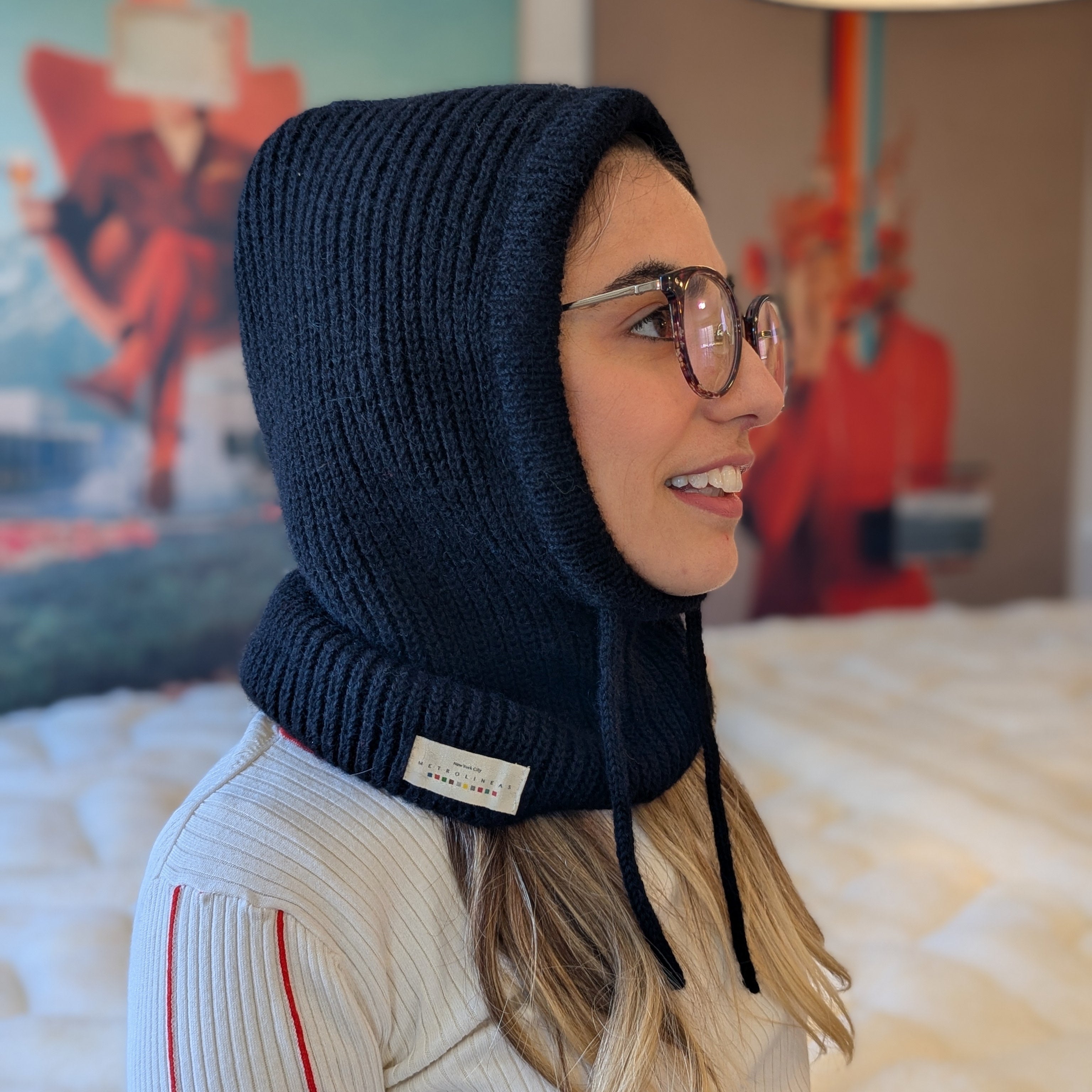 Woman wearing a black knitted hood in a room with colorful decor
