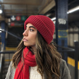 Girl wearing red scarf and red beanie in subway station