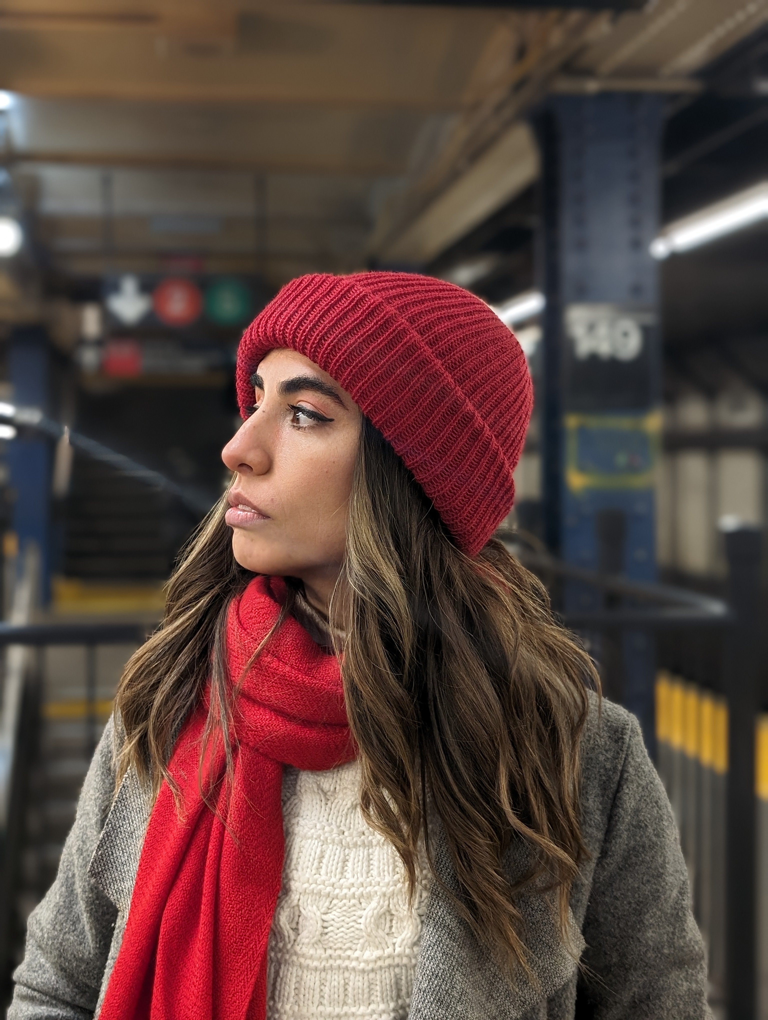Girl wearing red scarf and red beanie in subway station